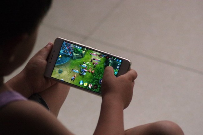 DEZHOU, CHINA - JULY 02:  A child plays online game 'Honor of Kings' on July 2, 2017 in Dezhou, Shandong Province of China. China's Tencent will restrict each account's daily playtime of its popular role-playing mobile game 'Honor of Kings', the developers said on Sunday. Children under 12 will be allowed to play the game for no more than an hour a day, and adolescents over 12 years old can play for two hours a day starting from Tuesday. It's an attempt to prevent them from online game addiction.  (Photo by VCG/VCG via Getty Images)